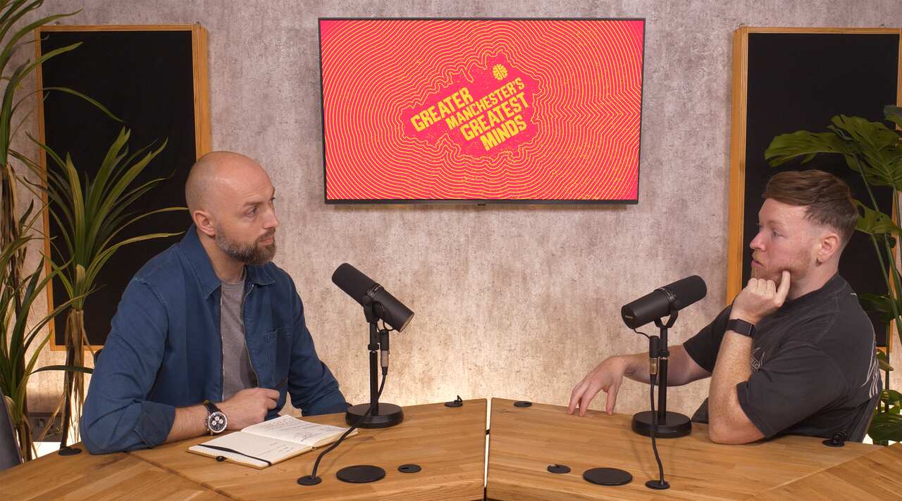 Two people mid-conversation on a filmed interview set.